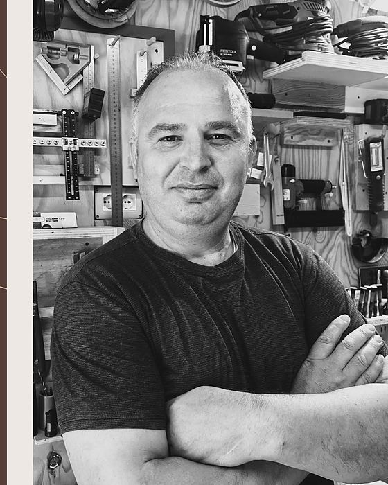 Artan Danaj in laboratorio, davanti a utensili e strumenti per la lavorazione del legno