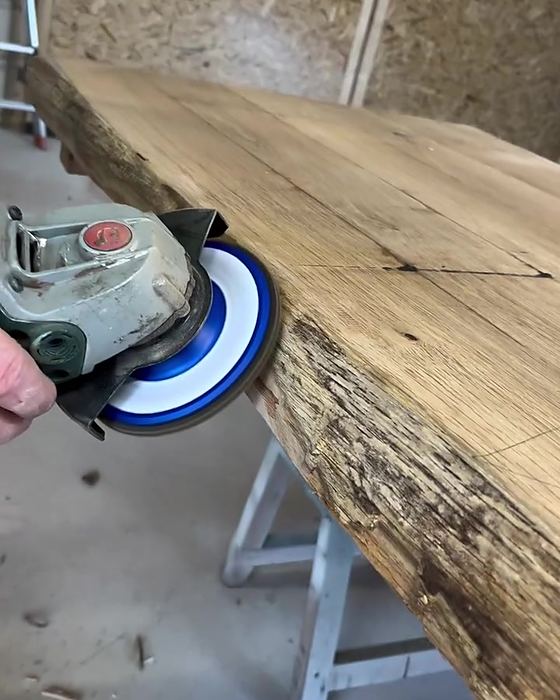Levigatura del bordo di un piano in legno con smerigliatrice